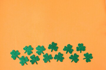 St. Patricks Day border paper shamrocks on orange background. Copy space for the text