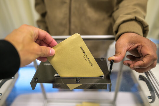 View of a person cast his ballot as he votes for the European elections at a polling station in France