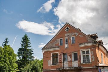 Old neglected and crumbling nice countryside town house on sunny day