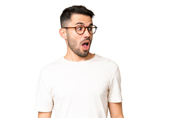 Obraz premium Young handsome caucasian man over isolated chroma key background doing surprise gesture while looking to the side