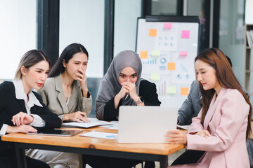 Obraz premium Business team intensely focused on analyzing data displayed on a laptop during a strategic office meeting.