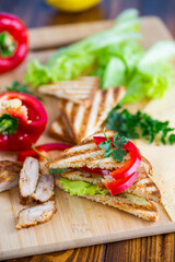 fried toast with chicken, salad, greens on a wooden table