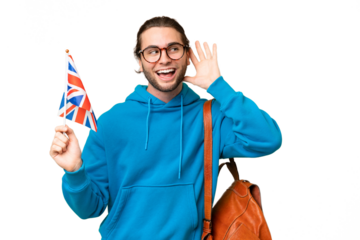 Young handsome man holding an United Kingdom flag over isolated background listening to something by putting hand on the ear