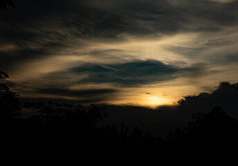 Obraz premium The sky is dark and cloudy with a sun in the background