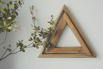 Unique wooden frame with angular edges, artistically hung on a white wall, adorned with a green potted plant