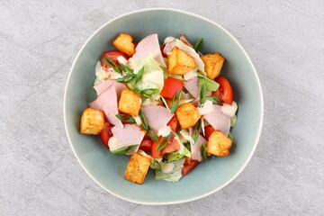 Salad with spinach, cheese, ham, grapefruit and balsamic sauce on a wooden rural background. Top view. Close-up.