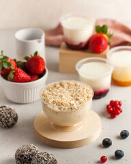 Dairy desserts with berries and candies on kitchen table
