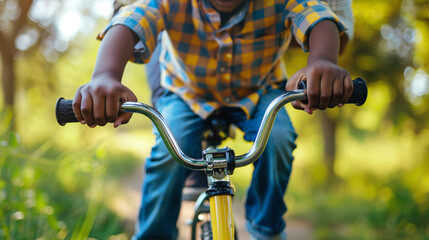 Close-up of a father teaching a child to ride a bike, hands on the handlebars