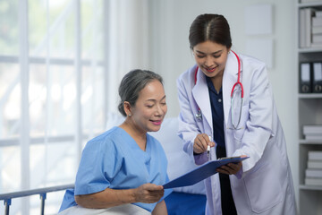 Doctor discussing medical report with elderly patient in hospital. Healthcare professional...