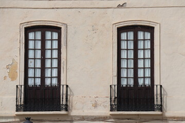 Windows with steel lattice on a whitewashed wall. Andalusian white village. Costa del Sol. Spain