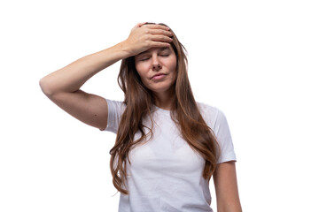 Fototapeta premium A young woman of European appearance is puzzled and holds her head