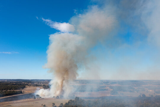 plume of smoke rising from fire on rural farming property