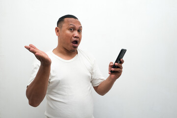 photo of the shocked expression of an Asian man looking at a mobile phone in his hand