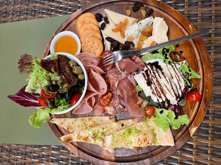 Cold cuts and Cheese board served with honey, crackers
