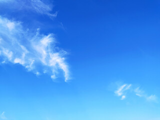 Clear blue sky texture and white fluffy cloud nature background. The sun shines bright in the...