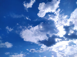 Obraz premium Clear blue sky texture and white fluffy cloud nature background. The sun shines bright in the daytime in summer