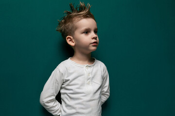 Little Boy Standing in Front of Green Wall