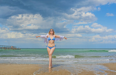 Fototapeta premium Concept of beach recreation, vacation time at warm climate. Girl on a sunny day at sea