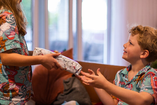 kids in matching pyjamas exchanging christmas gifts