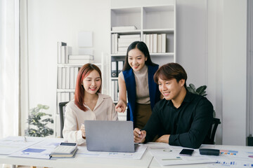 Young Professionals Collaborating in Modern Office Environment with Laptops and Documents, Engaging in Productive Teamwork and Brainstorming Sessions