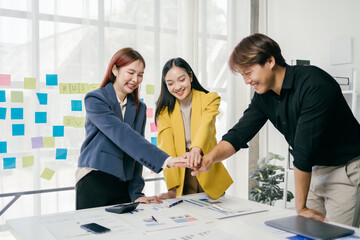 Young Professionals Collaborating in Modern Office with Business Documents and Colorful Sticky Notes on Glass Wall