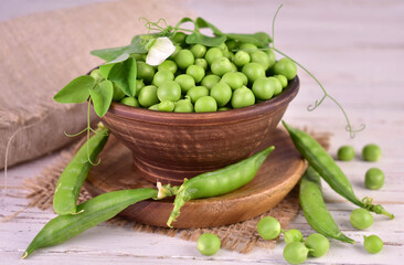 Green young peas in a clay bowl.Close-up.
