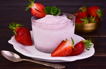 Strawberry ice cream in a glass glass and strawberries.
