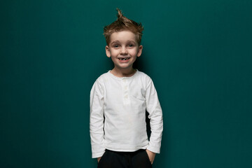 Little Boy Standing in Front of Green Wall