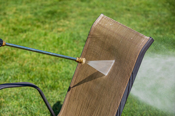 Cleaning patio furniture with pressure washer. Spring cleaning, household chores and home...