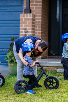 Parent bending down to childs level to talk with him outside home