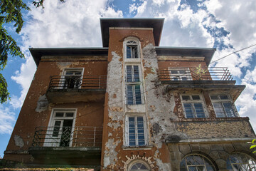 Old neglected and crumbling nice countryside town house on sunny day