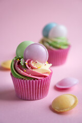 Delicious set of colourful cupcakes on pink background with flying saucers and sweets