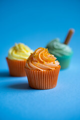 Delicious set of cupcakes on blue background with lemon zest