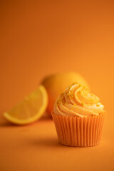 Delicious orange cupcake on orange background with fresh orange
