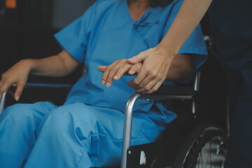 Obraz premium Doctor giving hope. Close up shot of young female physician leaning forward to smiling elderly lady patient holding her hand in palms. Woman caretaker in white coat supporting encouraging old person