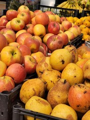 Ripe delicious apples and pears on the market in close-up. Autumn harvest of fruits and vegetables.