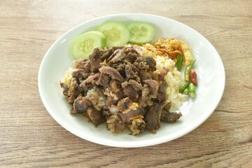 fried salty slice beef meat belly with crispy shallot and chili on rice couple cucumber in plate