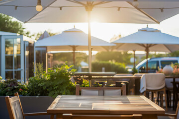 Sunset outdoor cafe seating with wooden tables and umbrellas, creating a bright and relaxing atmosphere for dining.