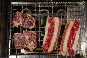 Korean Style Barbecue on stainless grill. BBQ rare meat with soft focus
