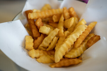 Close-up of French Fries served on paper in a bowl