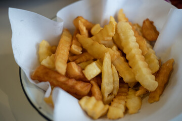 Close-up of French Fries served on paper in a bowl