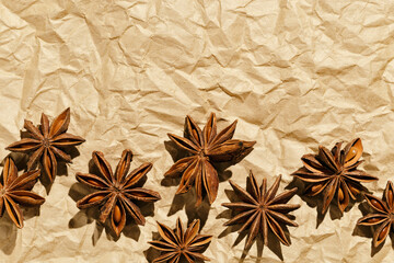 Anise stars pattern, above view close up flavor spices dried anise seeds on paper, still life with natural condiments, aromatic ingredient for cooking, rustic style food background, gastronomy theme