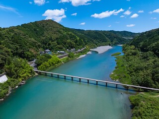 ドローン空撮。初夏、快晴の名越屋沈下橋と仁淀ブルー。高知県吾川郡いの町