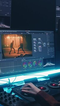 Female editor uses color grading control panel, edits video, makes movie color correction on computer and tablet in studio. Film footage and RGB wheels on monitor. Big screens with program interface.