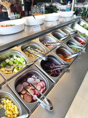 Buffet table stocked with an array of salads and veggies