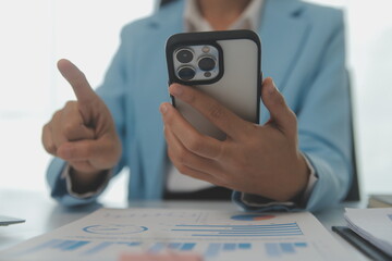 Portrait of a happy Asian businesswoman using mobile phone indoor, Asian businesswoman working in modern office.