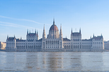 Fototapeta premium The neo-Gothic building of the Hungarian legislature, the Parliament with the river Danube flooding the quays in the foreground