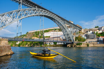View of Vila Nova de Gaia city with Mosteiro da Serra do Pilar monastery and Dom Luis I bridge over Douro river with traditional boat with port wine barrels. Porto, Vila Nova de Gaia, Portugal
