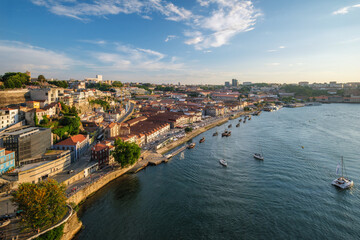 Fototapeta premium View of Vila Nova de Gaia city and Douro river with tourist boats on sunset. Porto, , Portugal
