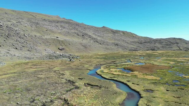 Beautiful landscape with stream, wetland, rocky terrain, clear sky, perfect for nature lovers